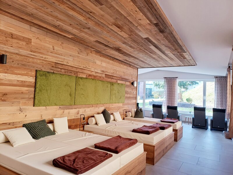 Frauen auf Ruheliegen vor Kamin